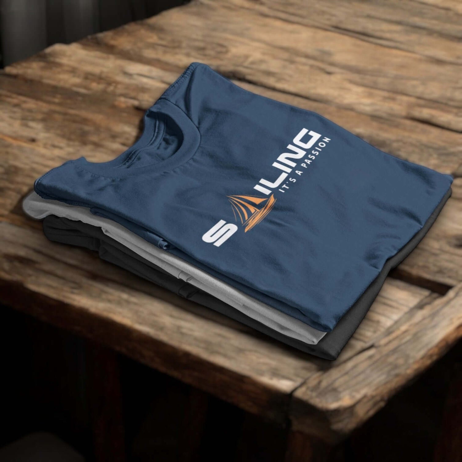 Stapel maritimer Herren-T-Shirts, oberstes Shirt mit Schriftzug ‚ Sailing – It’s a Passion‘ – maritime Kleidung für Herren.