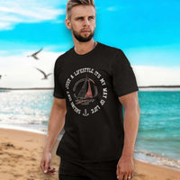 Junger Mann am Meer trägt maritime mode für Herren, genauer ein T-shirt mit Segel Motiv 