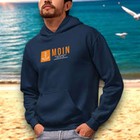 Mann am Meer trägt maritime mode für Herren, genauer ein Premium Hoodie mit Moin Motiv
