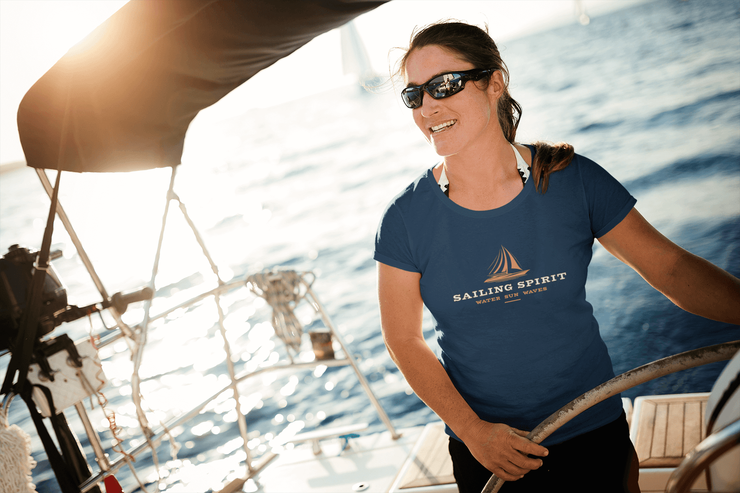 Frau auf einem Boot trägt ein Segeln T-Shirt mit dem Aufdruck 'Sailing Spirit' – maritimer Look für Segelfans.