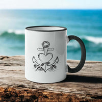 Keramiktasse mit Ankerherz vor Küste